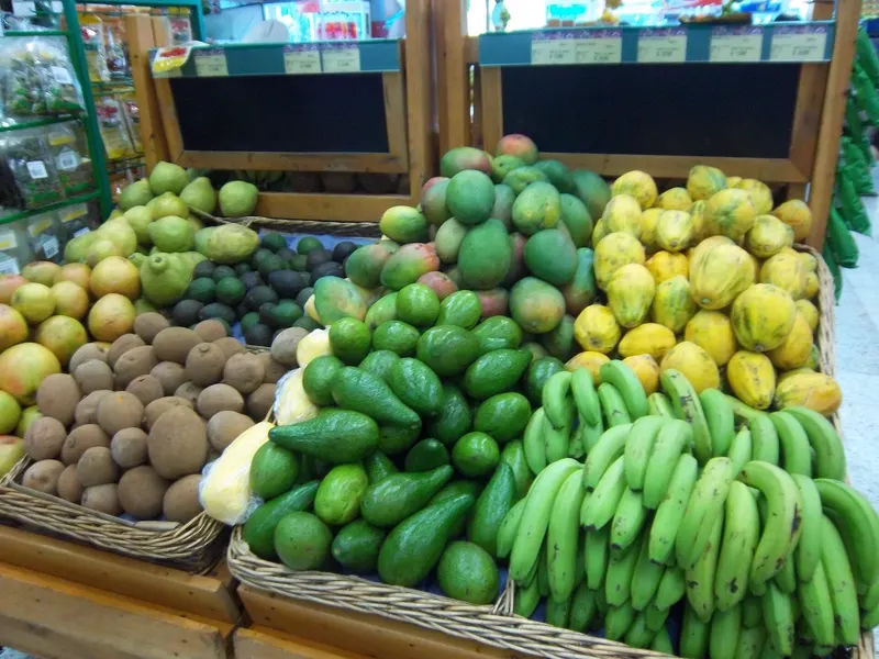 Puesto de frutas colombianas en un mercado, con mangos, papayas y bananos